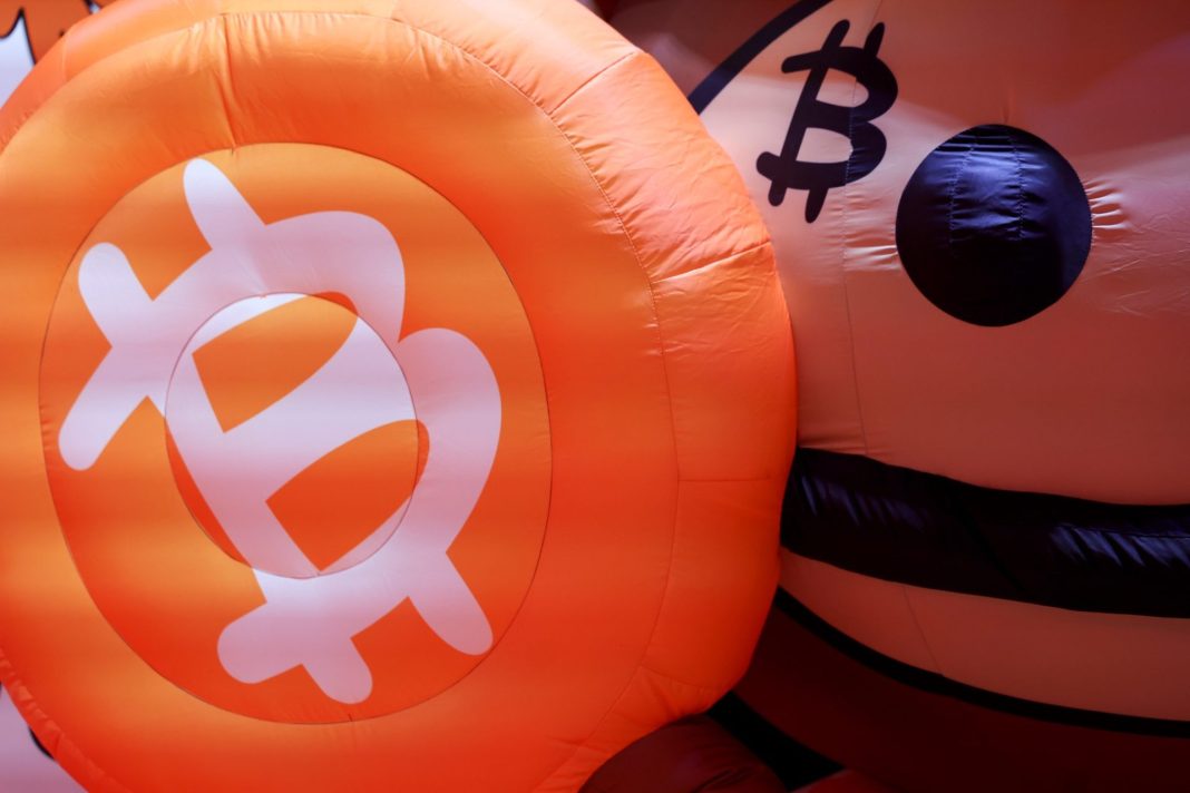 Oranžové nafukovací objekty se symbolem bitcoinu