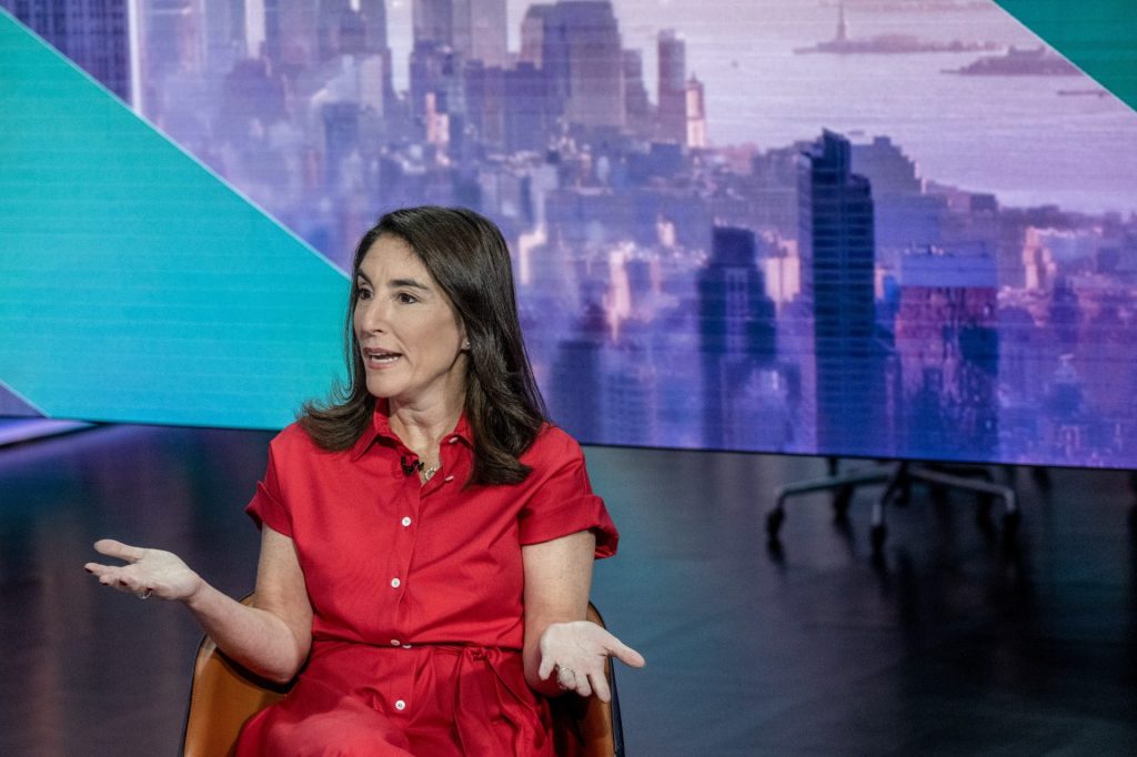 Žena v červených šatech hovoří při televizním rozhovoru