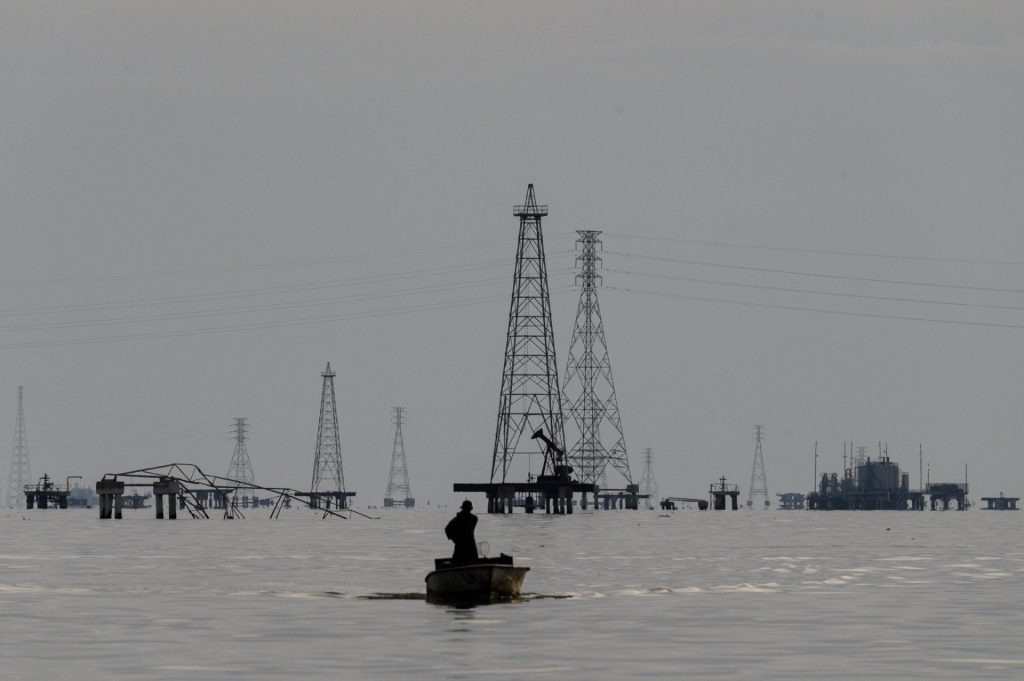 Ropné konstrukce a elektrické stožáry na vodní ploše s malým člunem v popředí
