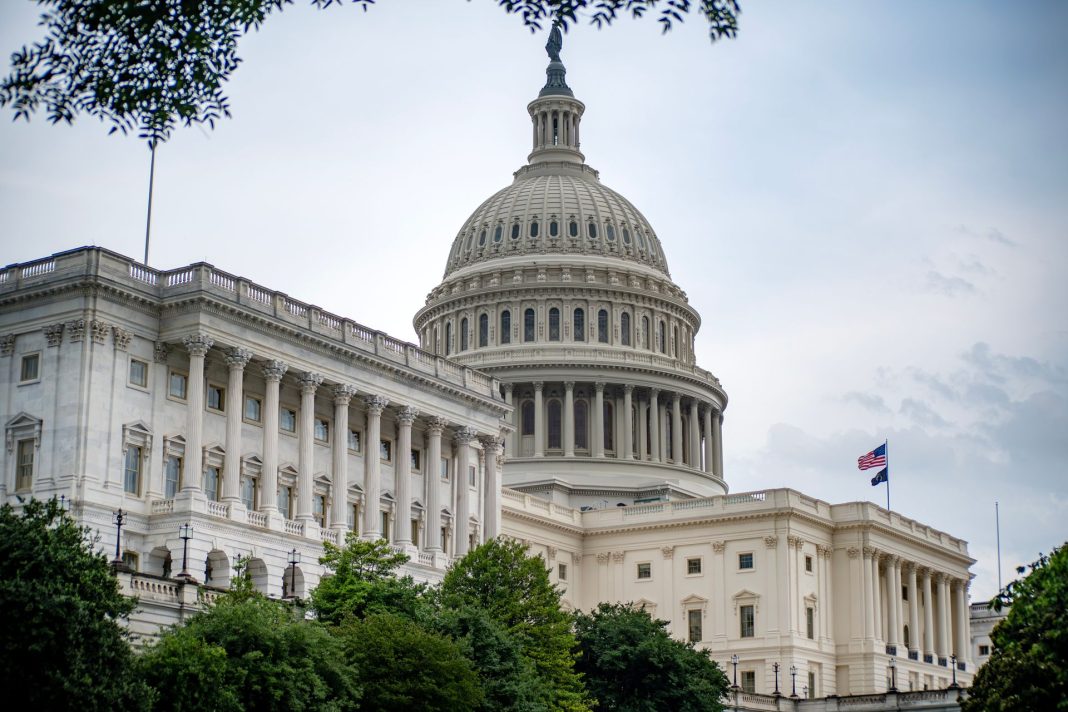 Budova Kapitolu Spojených států ve Washingtonu s kopulí a americkou vlajkou