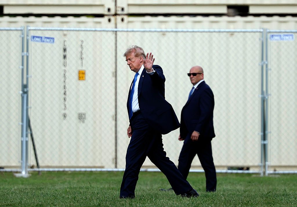 Donald Trump kráčí venku za doprovodu člena ochranky