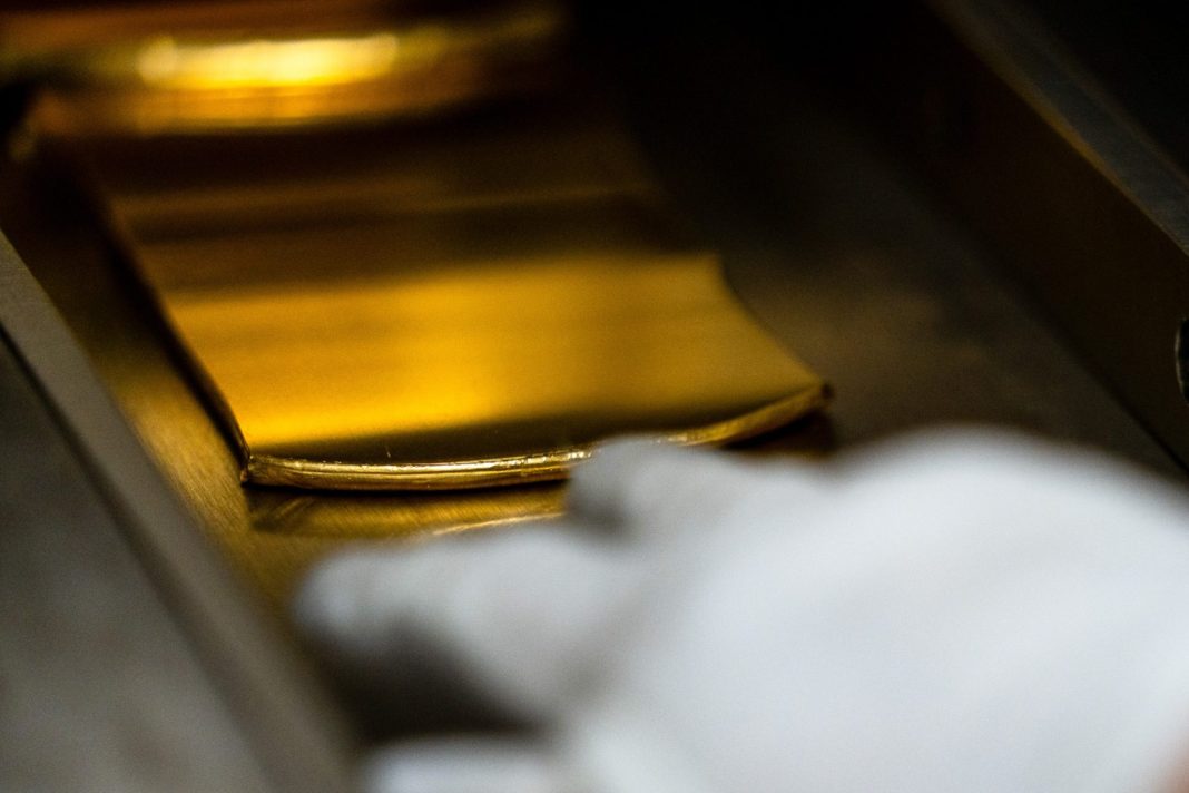 Detail zlaté cihly při manipulaci v provozu