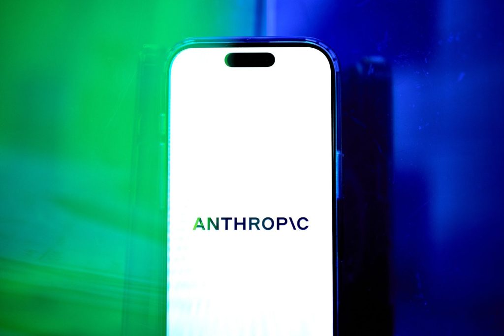 Logo společnosti Anthropic na displeji chytrého telefonu v zeleném a modrém osvětlení