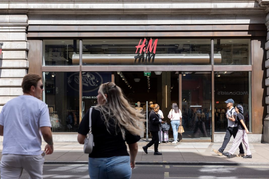 Vstup do prodejny H&M na nákupní ulici s chodci před výlohou