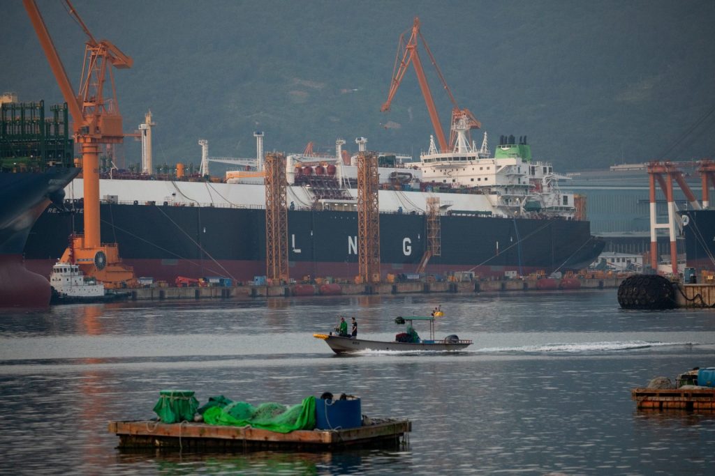LNG tanker zakotvený u přístavních jeřábů a průmyslové infrastruktury