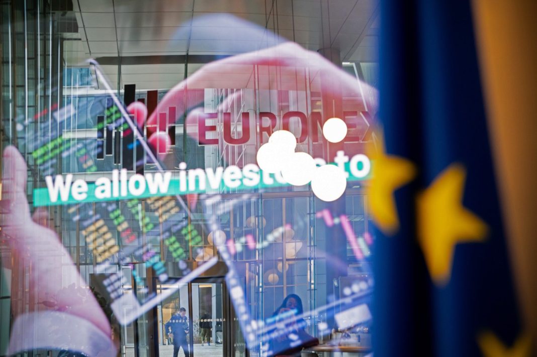 Budova burzy Euronext s odrazy barevných tržních grafů ve skle