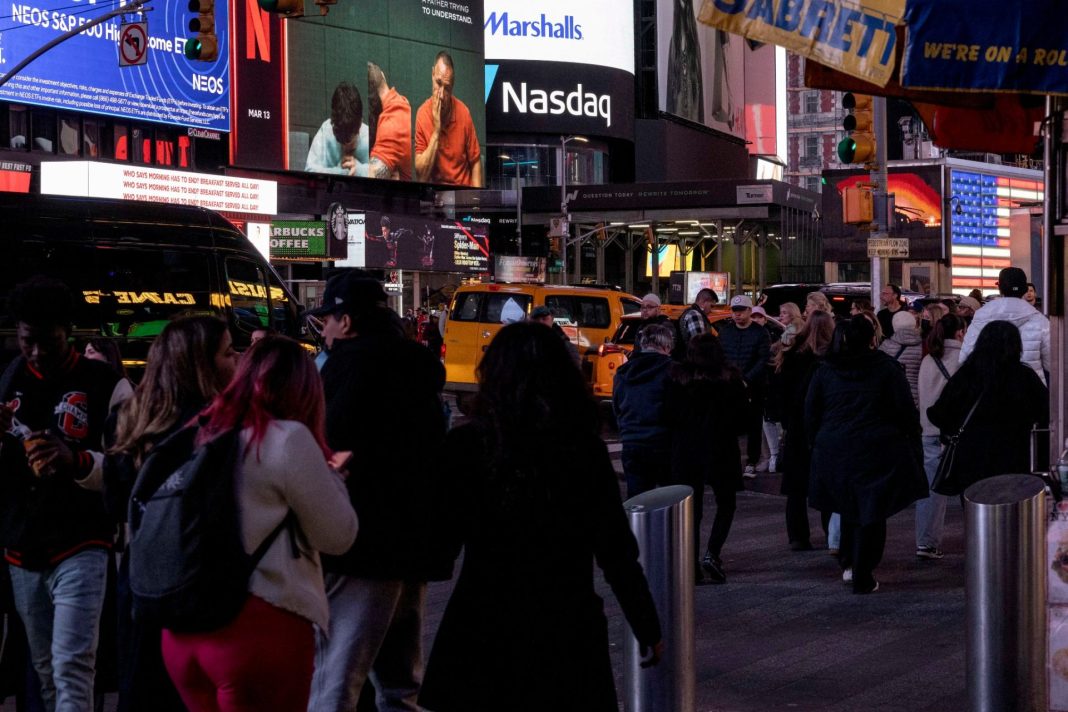 Times Square v New Yorku s reklamními obrazovkami a logem Nasdaq